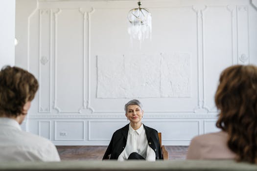 A therapist guides a counseling session with a couple in a modern office setting.