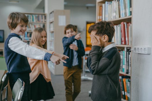 Group of children bullying a classmate in a school library setting.