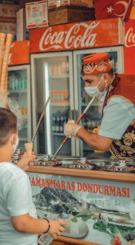 A boy waits eagerly as a Turkish vendor serves traditional ice cream.