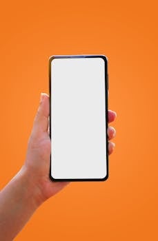 Mockup of a smartphone held against a bright orange background, ideal for app and interface presentations.