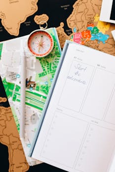 Flat lay of map, compass, and planner for travel planning and exploration.
