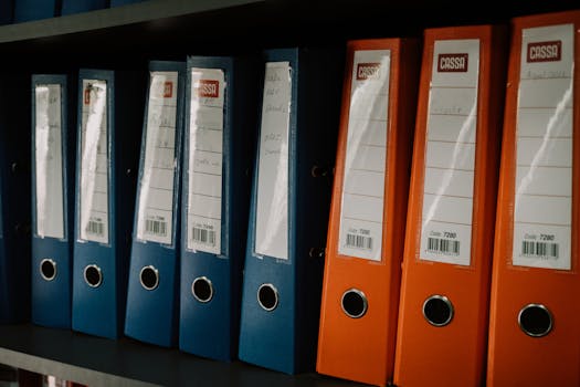 Row of colorful office binders neatly arranged on a shelf, ideal for organization concepts.