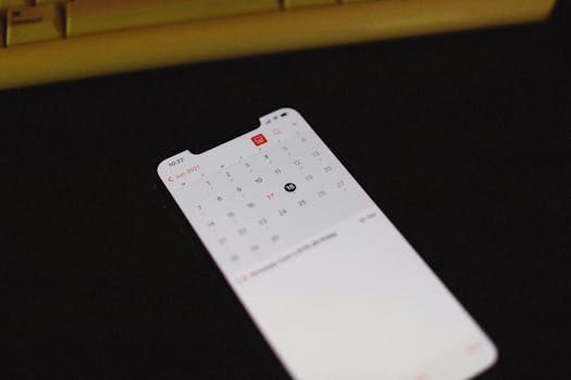 Smartphone with illuminated calendar app screen on a dark background, June 2021 visible.