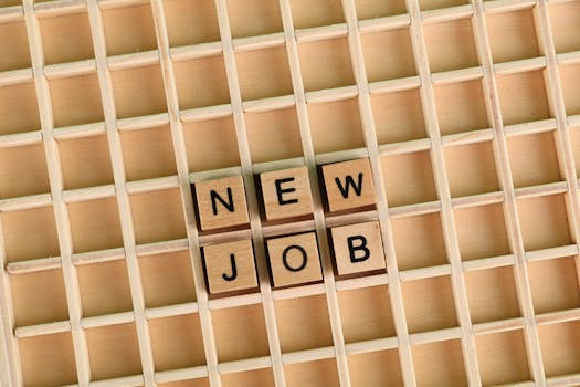 Discover the excitement of a new job with wooden letter tiles spelling 'NEW JOB' on a grid.