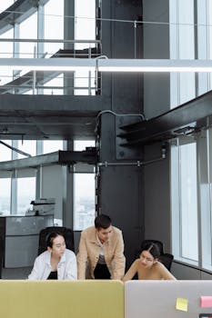 Three professionals collaborating in a modern office space